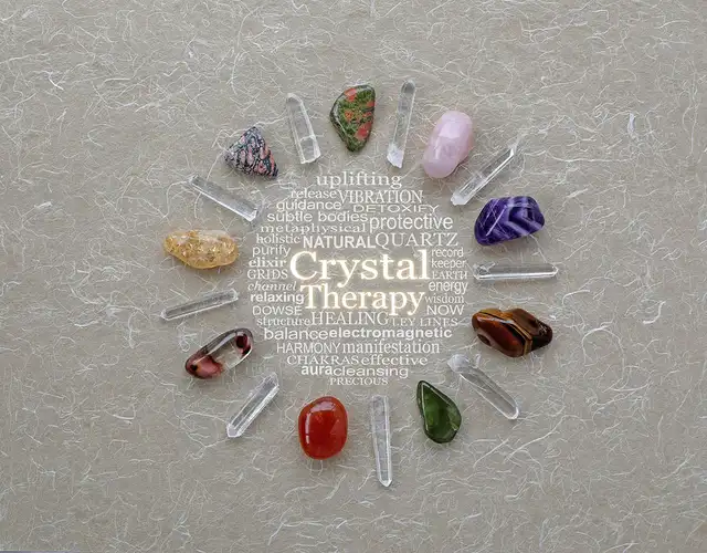 Eine kreisförmige Anordnung bunter Heilsteine, die den Text „Crystal Therapy“ und dazugehörige Stichwörter umrahmen.
