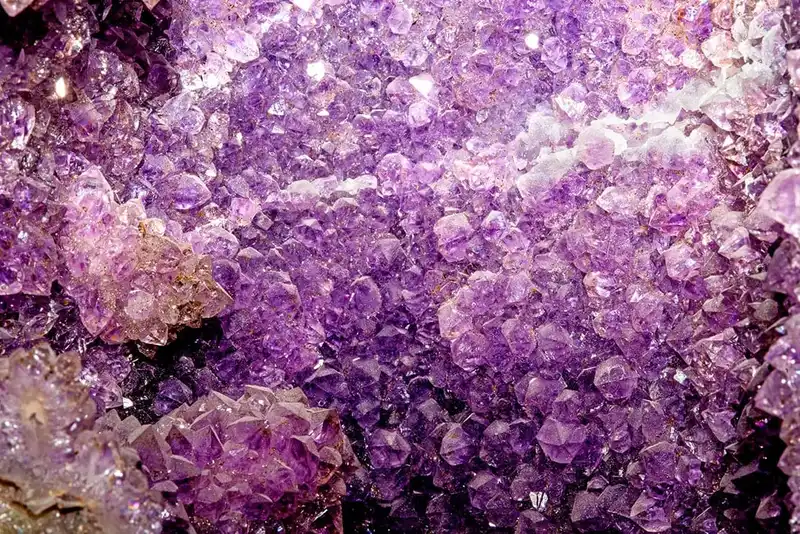 Nahaufnahme einer leuchtend violetten Amethyst-Geode mit kristallinen Strukturen als Heilstein.