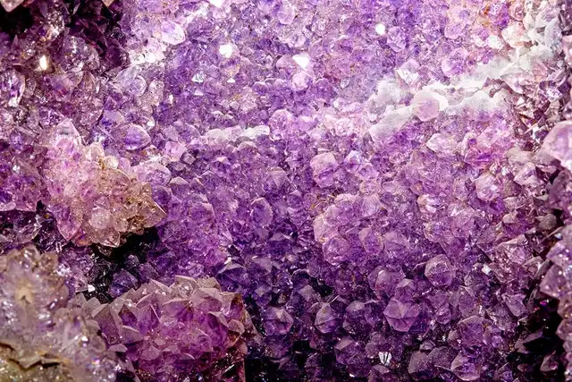 Nahaufnahme einer leuchtend violetten Amethyst-Geode mit kristallinen Strukturen als Heilstein.