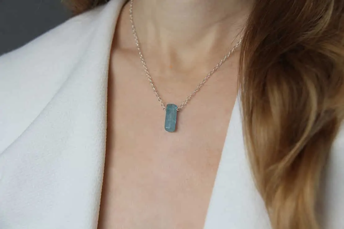 Frau trägt eine Halskette mit einem rechteckigen Seelenstein-Anhänger.