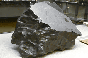 Ausgestellt wird ein großer, teilweise polierter Meteorit von Treysa mit seiner natürlich geformten, strukturierten Oberfläche und einem Schnitt, der die innere Struktur freigibt.