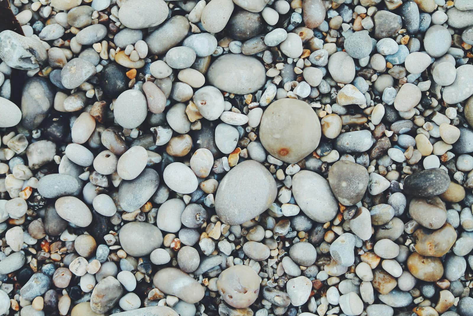 Verschieden große Kieselsteine an einem Strand, doch giftige Mineralien gehören nicht in Kinderhände!