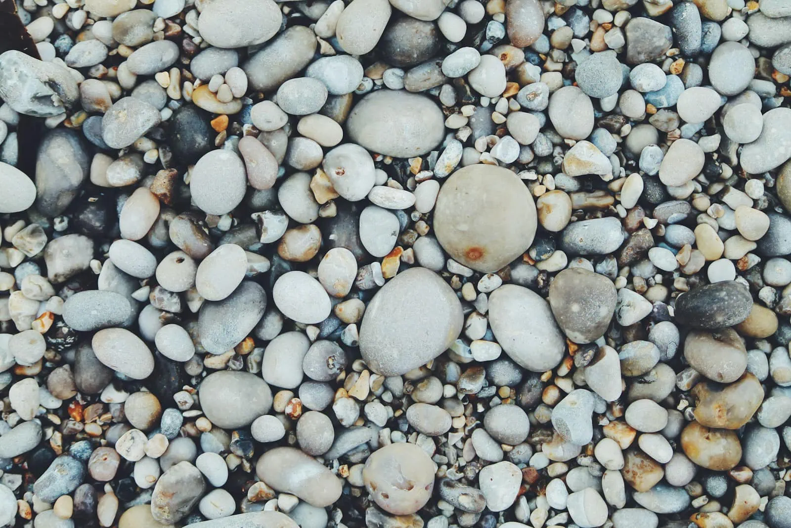 Verschieden große Kieselsteine an einem Strand, doch giftige Mineralien gehören nicht in Kinderhände!