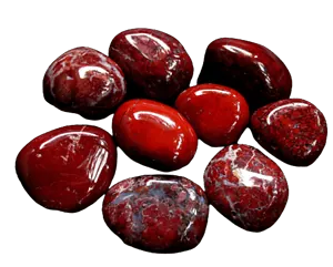 Polierte rote Jaspis-Edelsteine auf schwarzem Hintergrund.