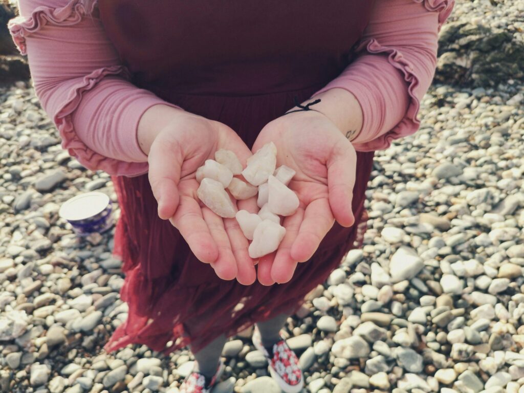 person in pink long sleeve shirt with white petals on hand