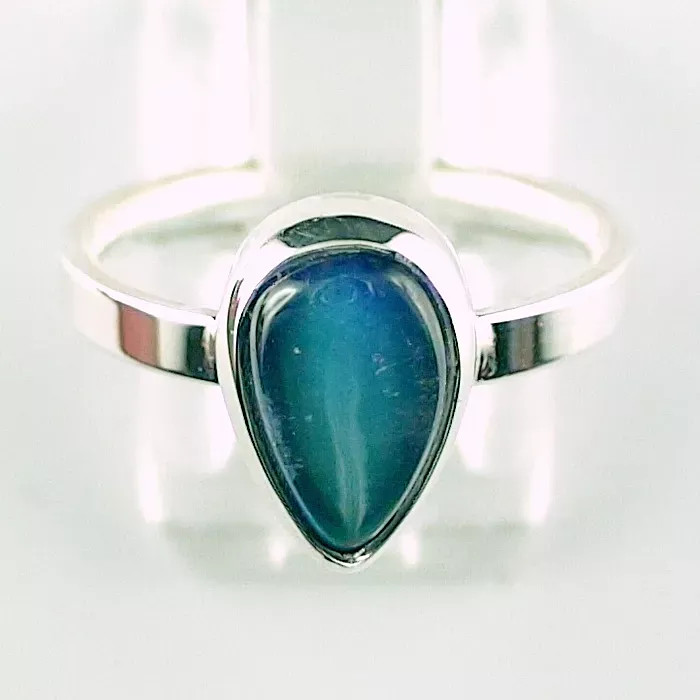 Ein Silberring mit einem tropfenförmigen blauen Stein in der Mitte.