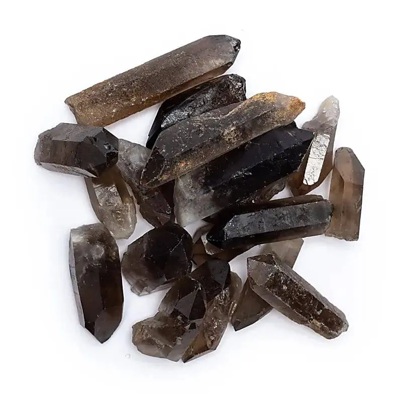 Mehrere dunkle, durchscheinende, natürliche Mineralkristalle unterschiedlicher Größe sind auf einem weißen Hintergrund verstreut.