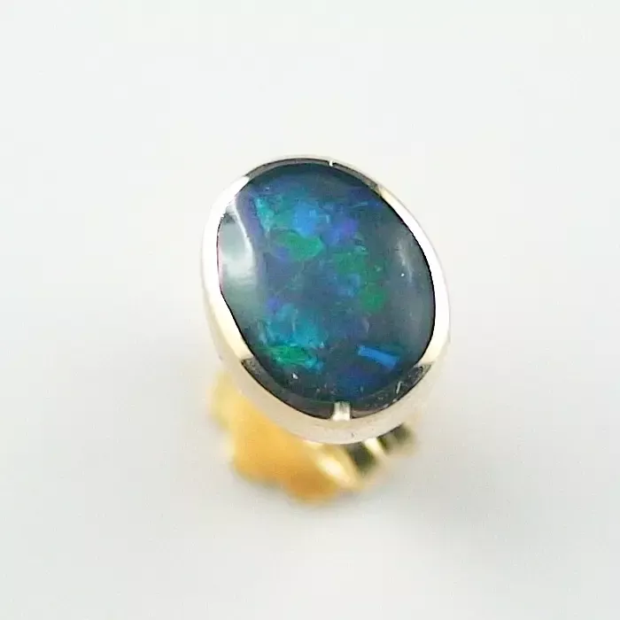Ein Ring mit einem ovalen Opal-Edelstein in einem Gelbgoldband.