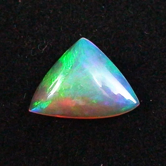 Dreieckiger Opal-Edelstein mit leuchtenden Grün-, Blau- und Rottönen auf schwarzem Hintergrund.