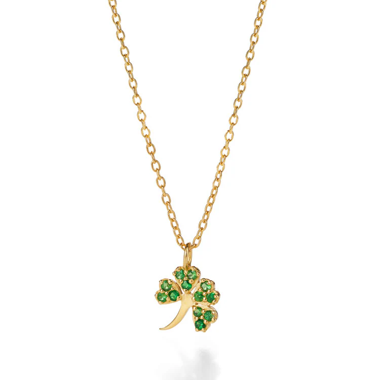 Eine goldene Halskette mit einem vierblättrigen Kleeblattanhänger. Das Kleeblatt ist mit kleinen grünen Edelsteinen geschmückt.