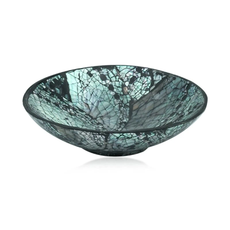 Eine Glasschale mit einem rissigen Mosaikmuster in Blaugrün- und Schwarztönen.