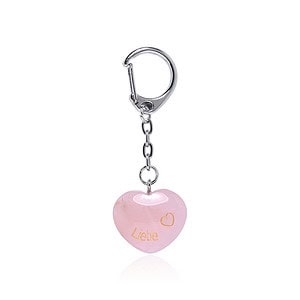 Ein herzförmiger rosa Schlüsselanhänger mit „Liebe“ und einem Herzsymbol in Gold. Er hat eine silberne Kette mit einem Verschluss.